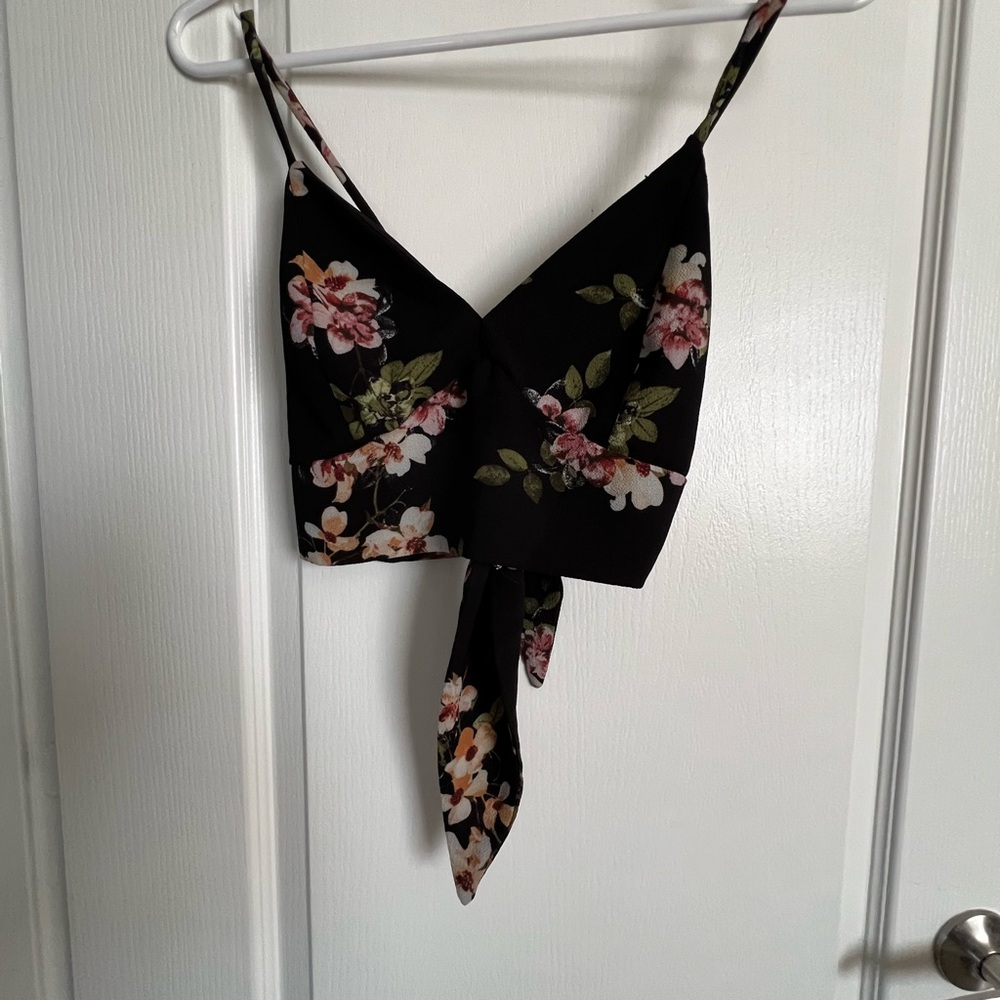 Black with floral printing v neck crop top. Ties in the back